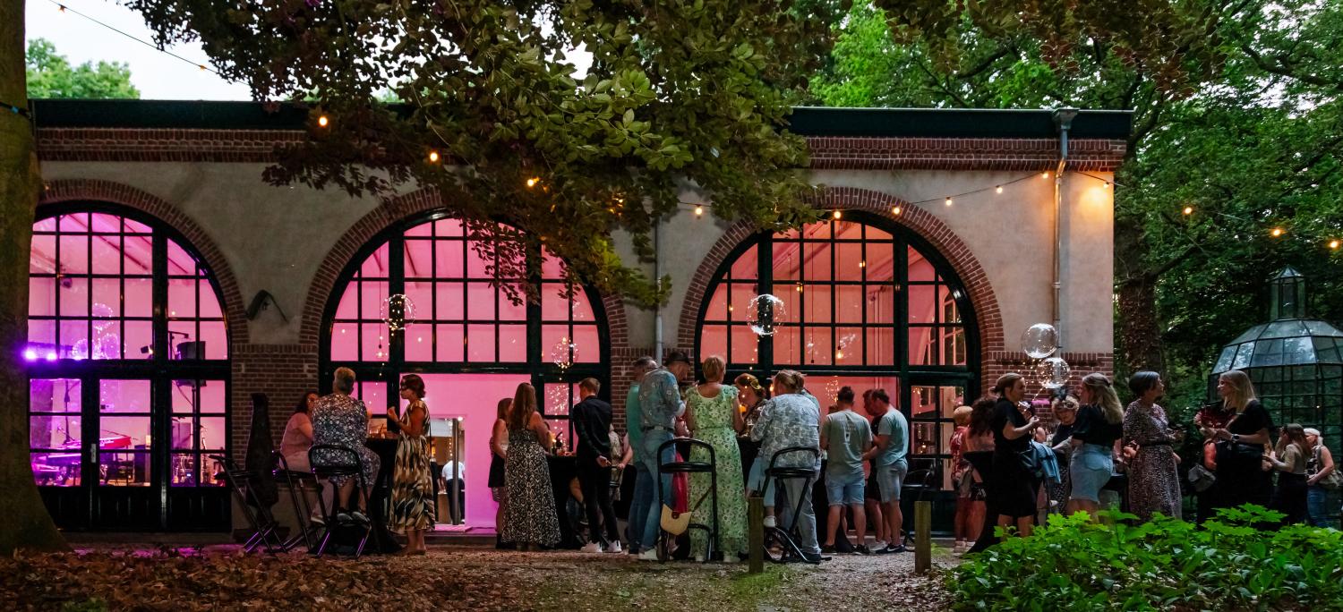 Feest van personeelsvereniging De Spuit, mensen die buiten aan tafels staan
